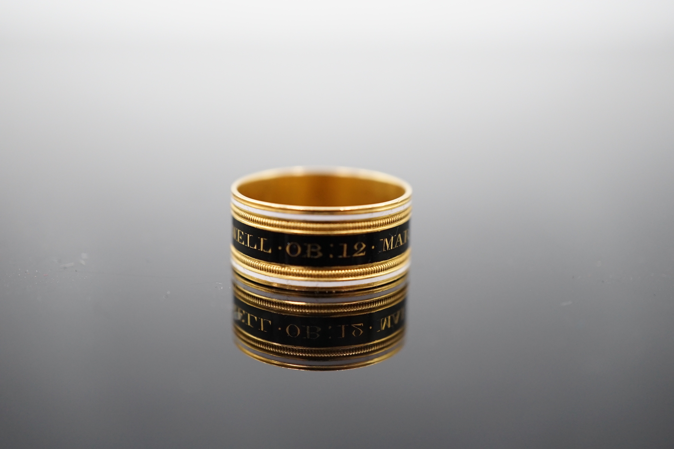 A George III 22ct gold and two colour enamel mourning band, inscribed 'Mary Powell OB. 12 Mar, 1809'